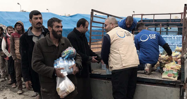 Distribution d’aide d’urgence en eau et vivres aux populations fuyant Mossoul au point dit de « Bagdad cycle ».